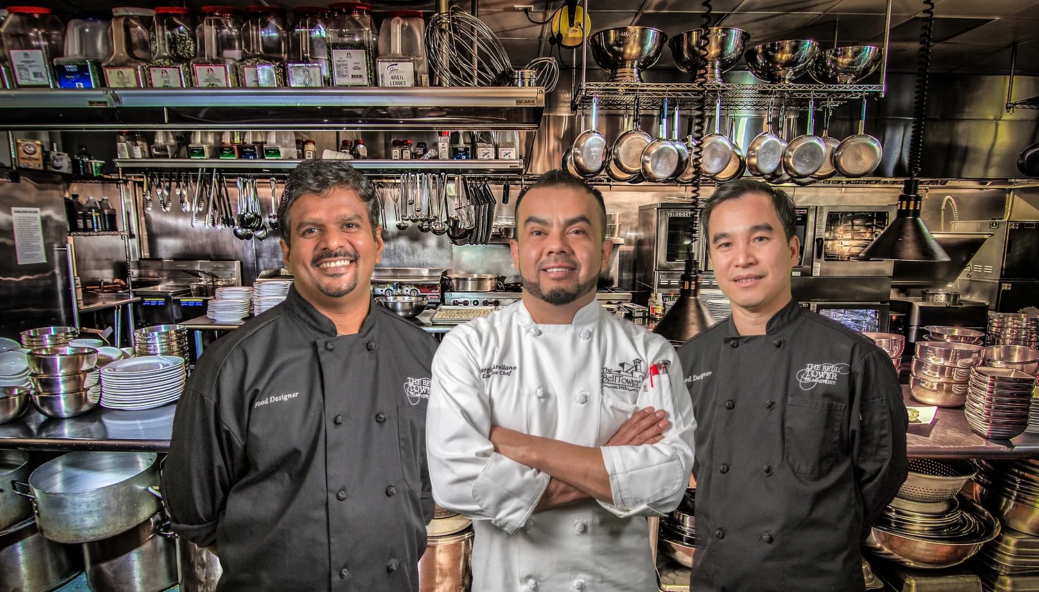 Executive chef and two culinary team members posing confidently in The Bell Tower on 34th's professional kitchen.