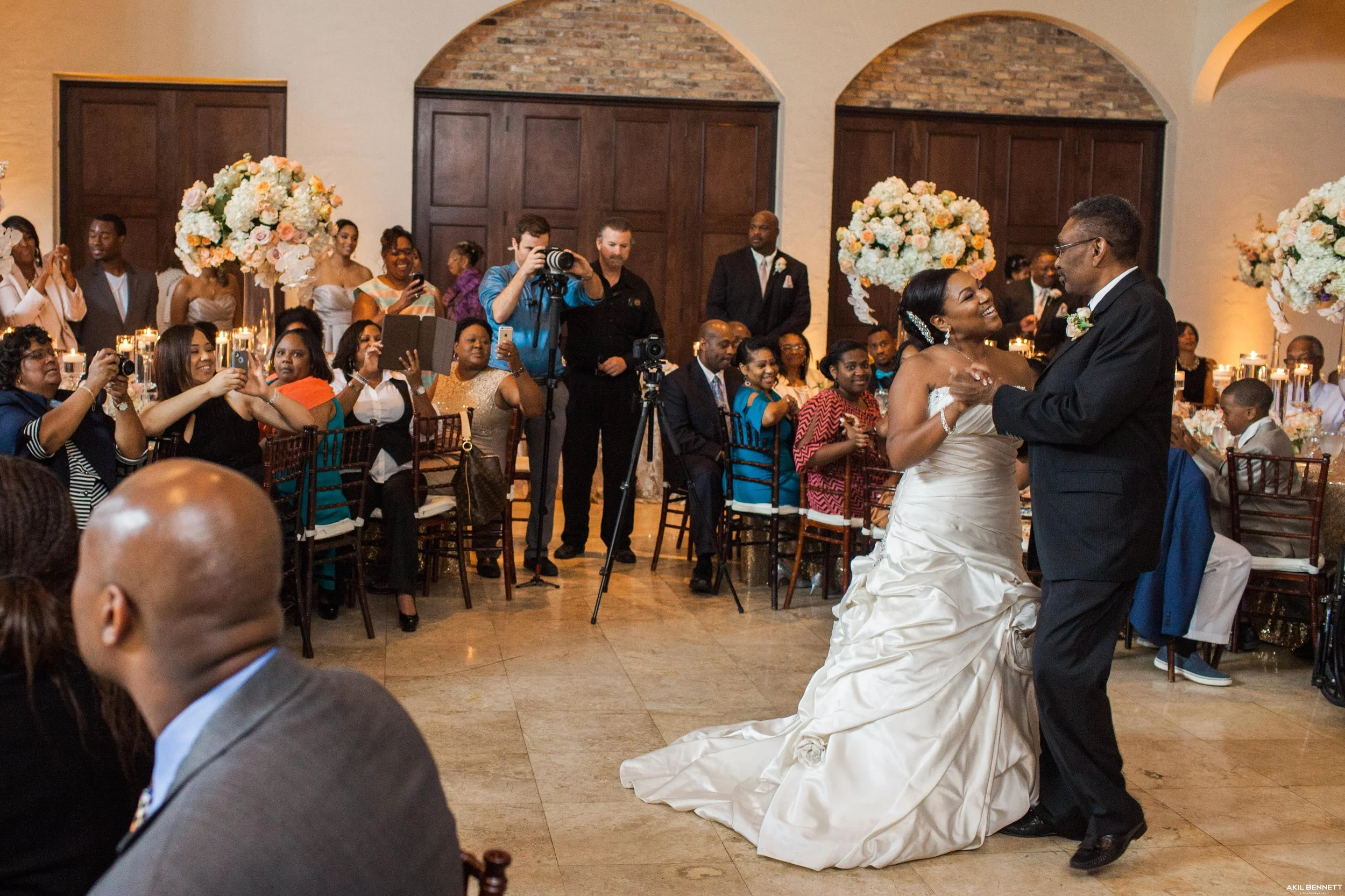 Bride dances with her father and smiles at him